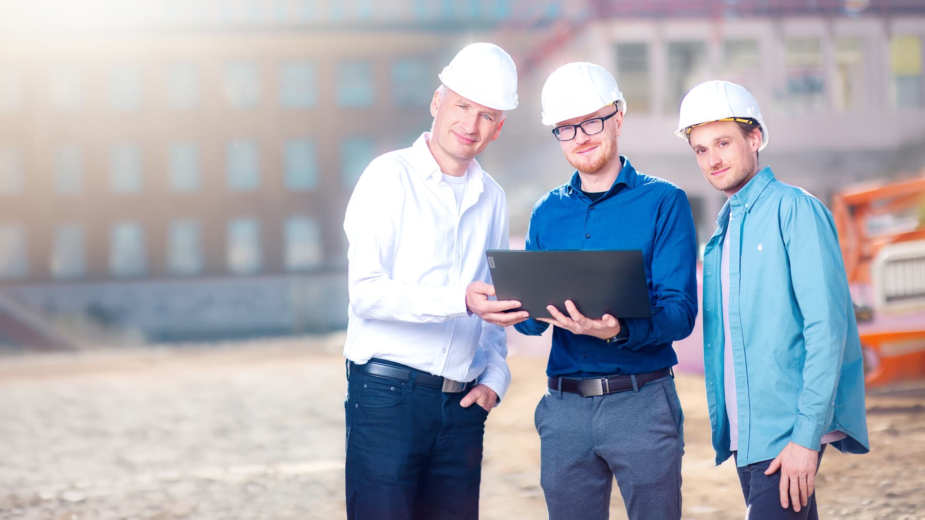 Bauleitung des IK-Ingenieurbüro Knoblich auf der Baustelle mit Laptop und Bauplan